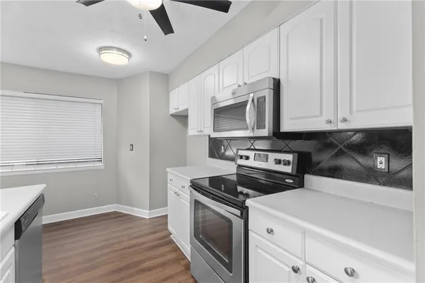 a kitchen with stainless steel appliances granite countertop a stove a microwave and a refrigerator