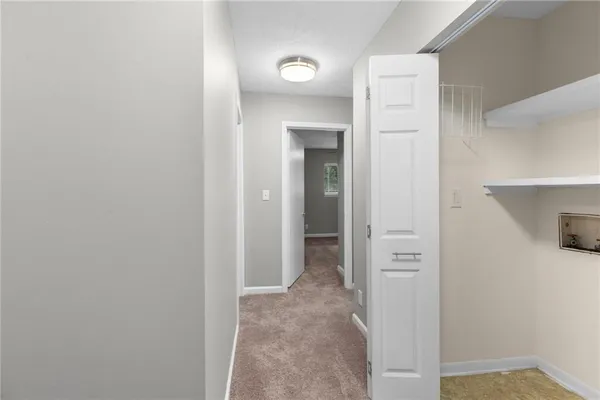 a view of a hallway with closet and bathroom