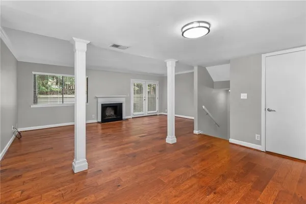 a view of empty room with wooden floor and fireplace