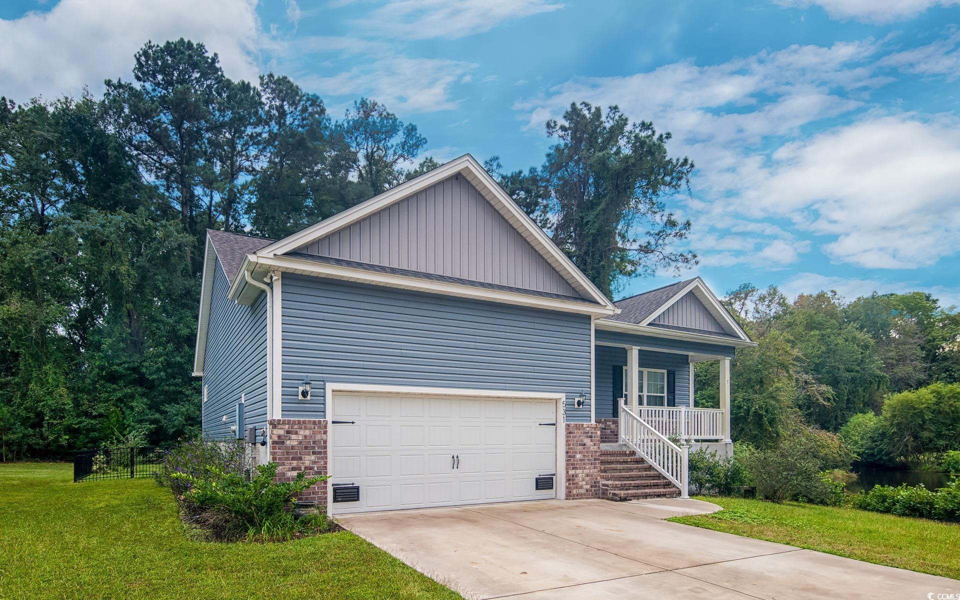 531 Charlton Boulevard Georgetown, SC 29440 - Photo 2 of 19 View of front of home with covered porch, brick siding, a front yard, and a garage