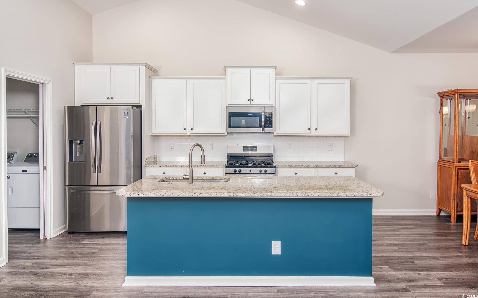 531 Charlton Boulevard Georgetown, SC 29440 - Photo 8 of 19 Kitchen featuring appliances with stainless steel finishes, light stone countertops, white cabinets, decorative backsplash, and dark wood-style flooring