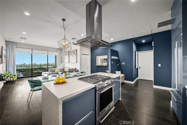 a kitchen with stainless steel appliances granite countertop a sink dishwasher and a stove with wooden floor