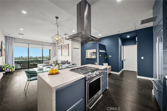 a kitchen with stainless steel appliances granite countertop a sink dishwasher and a stove with wooden floor