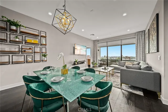 a view of a dining room with furniture a kitchen and chandelier