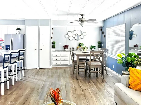 a view of a dining room and livingroom with furniture wooden floor a rug a potted plant and a chandelier