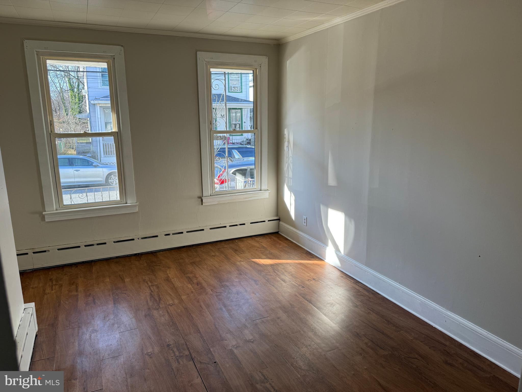 31 Bispham Street, Unit A Mount Holly, NJ 08060 - Photo 3 of 5 an empty room with wooden floor and windows