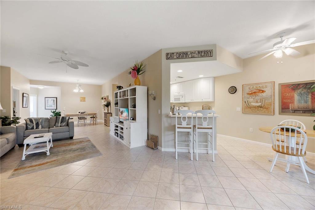 3955 Deer Crossing Court, Unit 103 Naples, FL 34114 - Photo 11 of 40 a living room with furniture and a flat screen tv