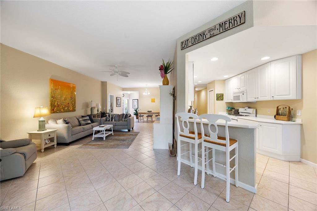 3955 Deer Crossing Court, Unit 103 Naples, FL 34114 - Photo 12 of 40 a living room with furniture and a large window