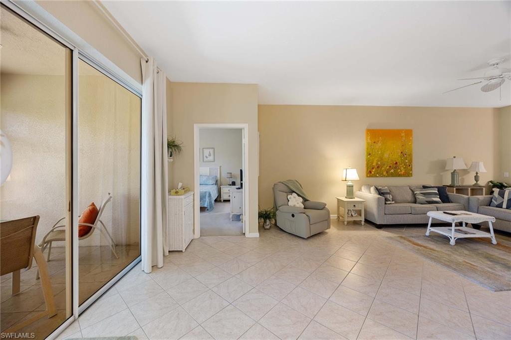 3955 Deer Crossing Court, Unit 103 Naples, FL 34114 - Photo 13 of 40 a living room with furniture and a large window
