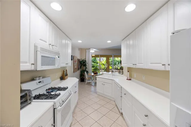 a kitchen with white cabinets and appliances