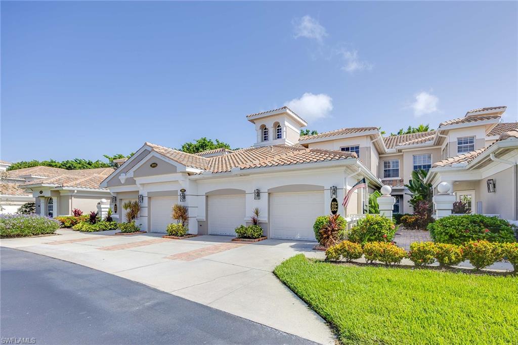 3955 Deer Crossing Court, Unit 103 Naples, FL 34114 - Photo 2 of 40 a front view of a house with a yard and potted plants