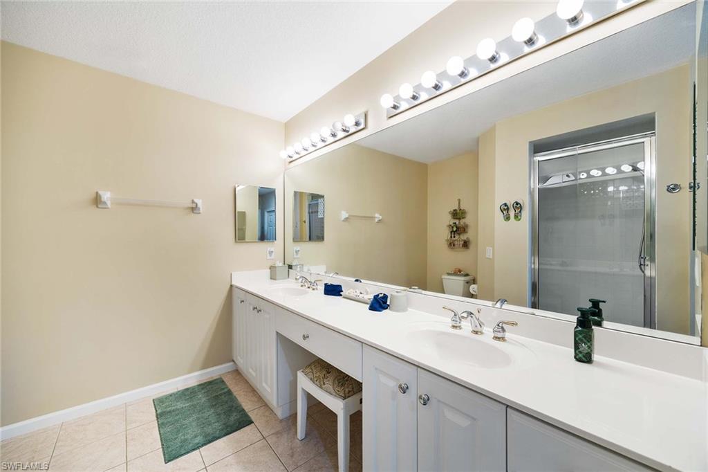 3955 Deer Crossing Court, Unit 103 Naples, FL 34114 - Photo 21 of 40 a bathroom with a sink and a mirror