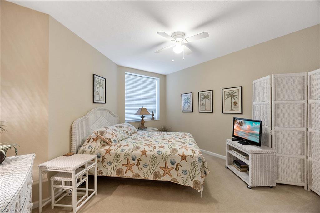 3955 Deer Crossing Court, Unit 103 Naples, FL 34114 - Photo 26 of 40 a bedroom with a bed and a flat screen tv
