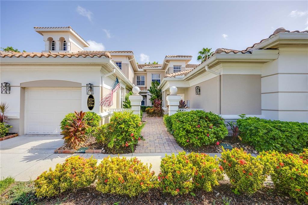 3955 Deer Crossing Court, Unit 103 Naples, FL 34114 - Photo 3 of 40 a view of a house with potted plants and large windows