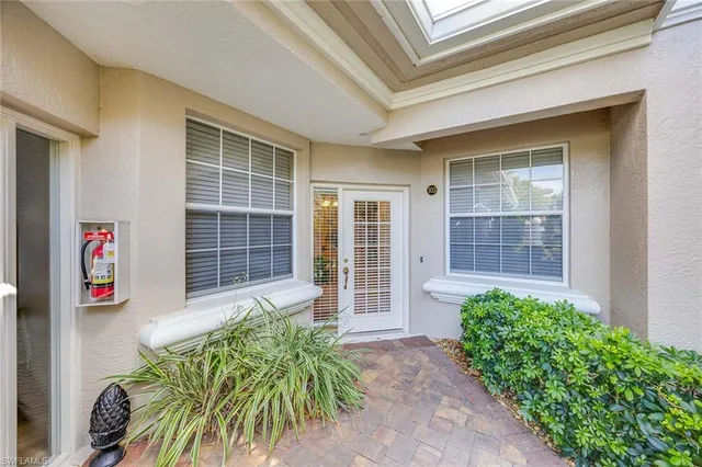a house with a lot of potted plants in front of door