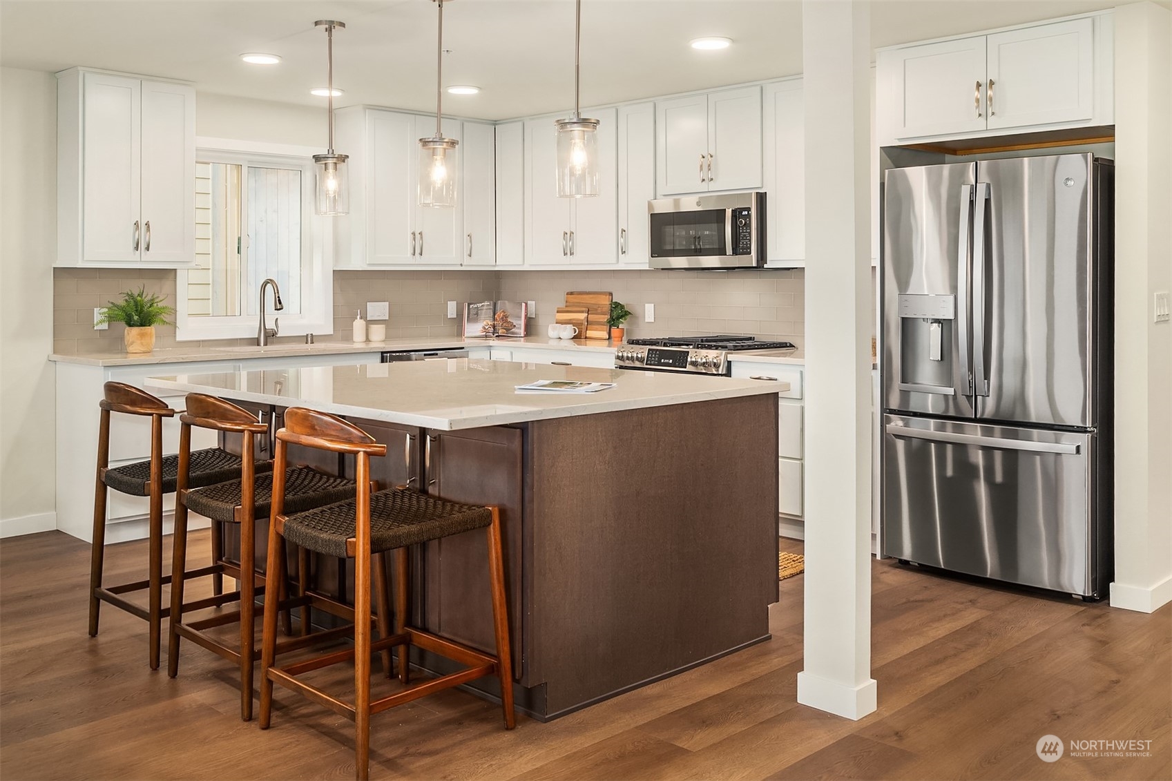 546 Paradise Lane, Unit A202 Edmonds, WA 98020 - Photo 14 of 30 a kitchen with kitchen island granite countertop a table chairs refrigerator and microwave