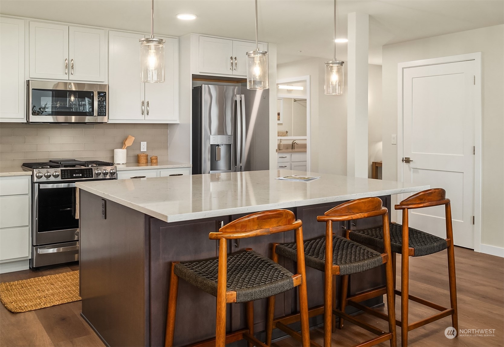 546 Paradise Lane, Unit A202 Edmonds, WA 98020 - Photo 16 of 30 a kitchen with stainless steel appliances granite countertop a stove a refrigerator and a dining table with wooden floor