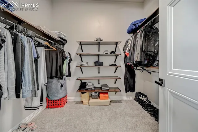 a view of walk in closet with clothes and shoes
