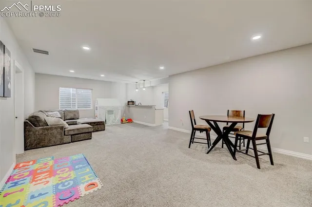 a living room with furniture and a dining table with kitchen view