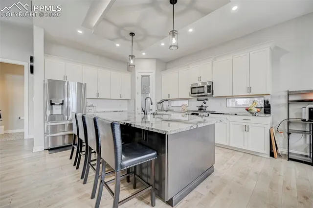 a kitchen with white cabinets stainless steel appliances and kitchen island