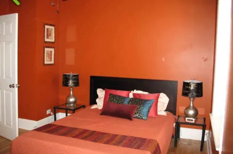 a bedroom with a bed and a lamp with the view of entryway