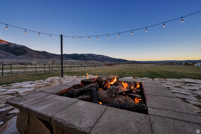 352 East Boulderville Road Oakley, UT 84055 - Photo 48 of 62 Patio terrace at dusk featuring a mountain view, a patio, and a fire pit