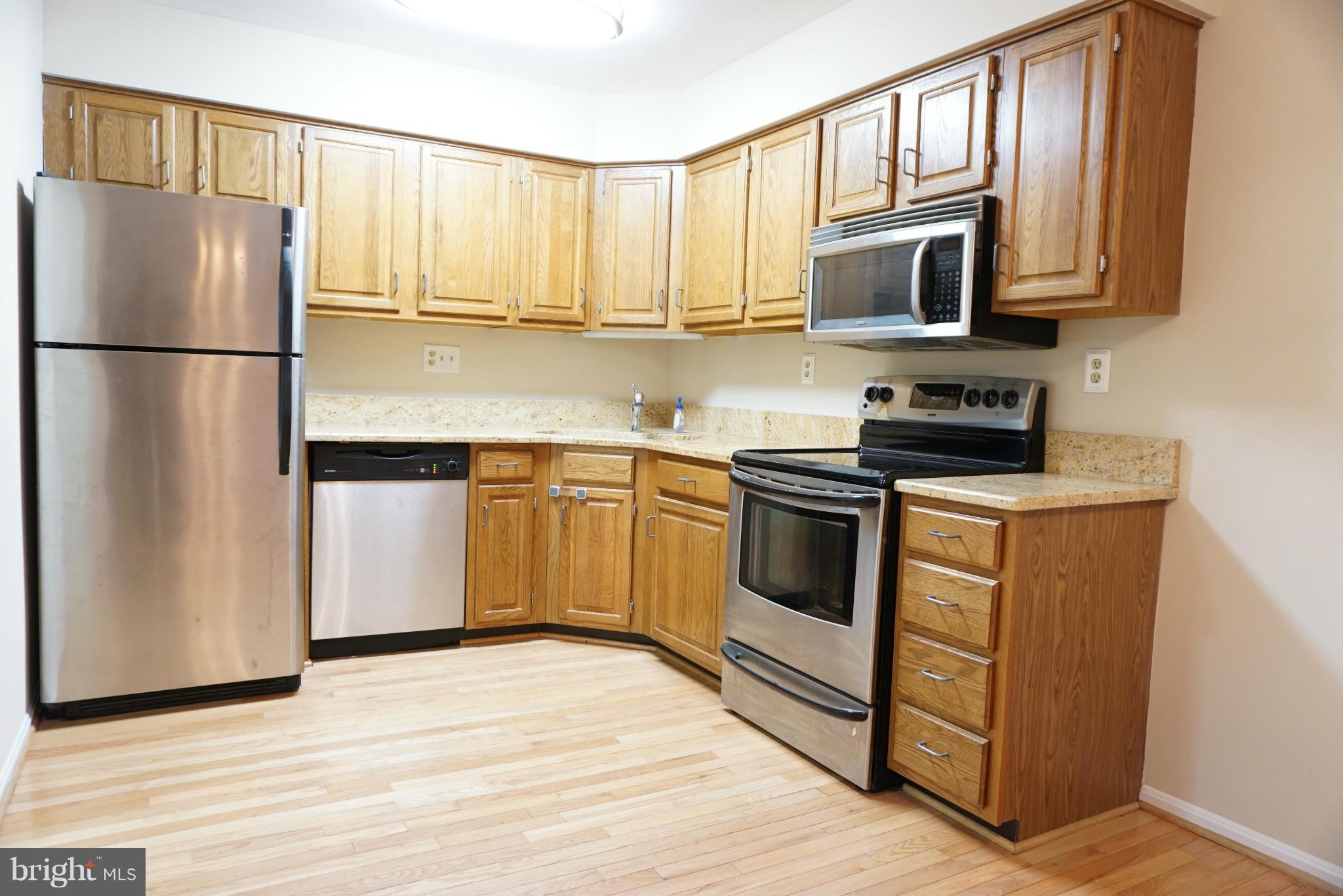 14405 Colonels Choice Road Upper Marlboro, MD 20772 - Photo 5 of 18 a kitchen with stainless steel appliances granite countertop a refrigerator stove a sink and a microwave