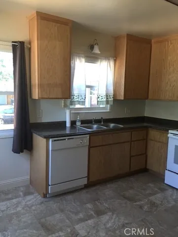 a kitchen with granite countertop a sink and a stove