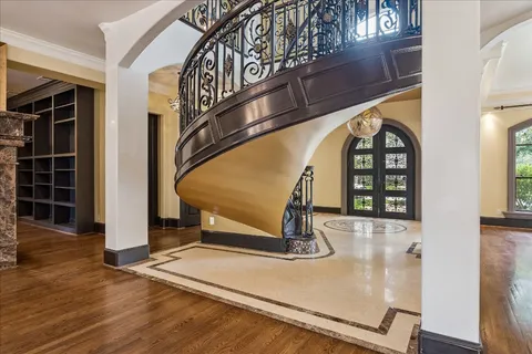 a view of a hallway with wooden floor and windows