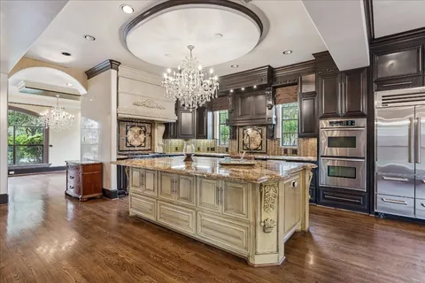 a kitchen with stainless steel appliances granite countertop a stove and cabinets