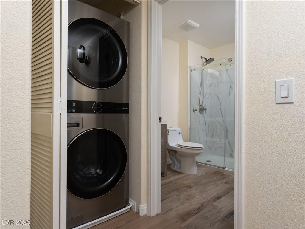 3318 North Decatur Boulevard, Unit 2149 Las Vegas, NV 89130 - Photo 11 of 26 Washroom featuring a textured wall, estacked washer and dryer, and light wood finished floors