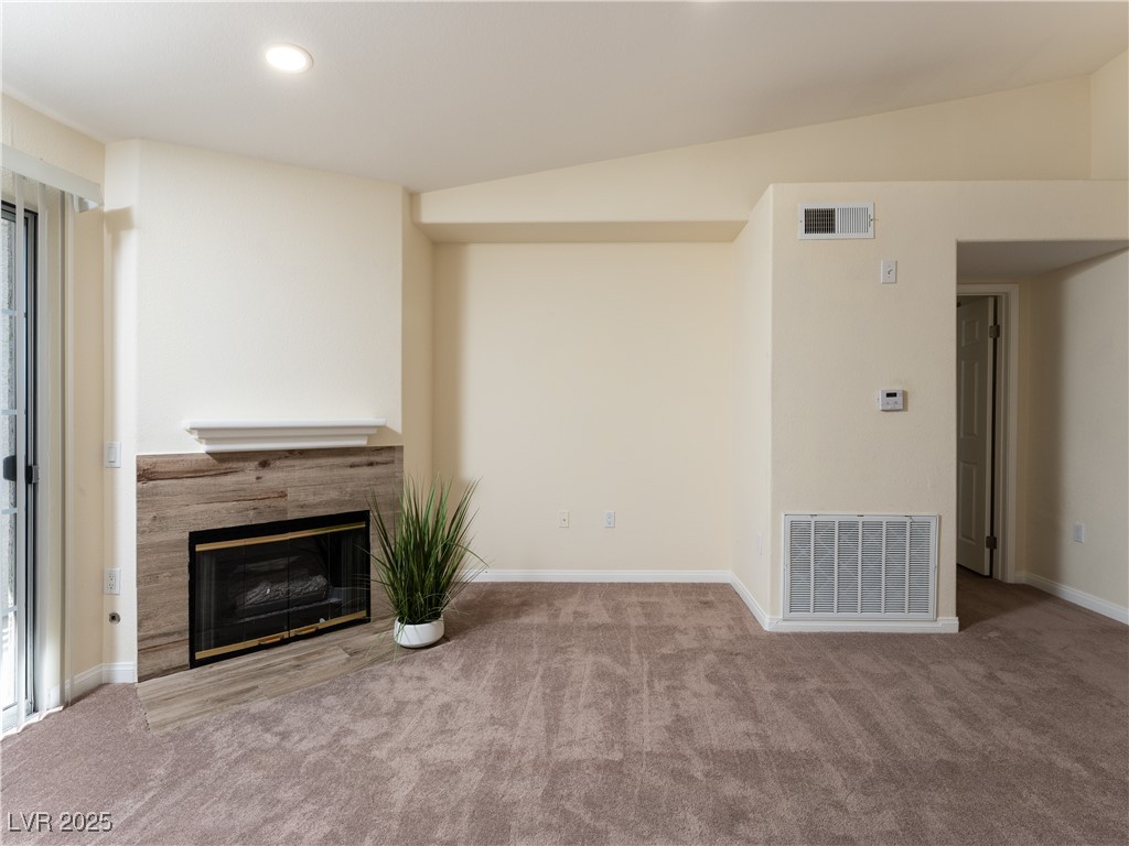 3318 North Decatur Boulevard, Unit 2149 Las Vegas, NV 89130 - Photo 13 of 26 Unfurnished living room with carpet, a tile fireplace, vaulted ceiling, and recessed lighting