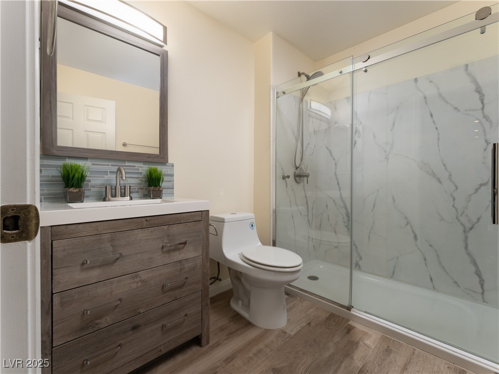 3318 North Decatur Boulevard, Unit 2149 Las Vegas, NV 89130 - Photo 17 of 26 Full bath featuring light wood-style floors, a marble finish shower, and vanity