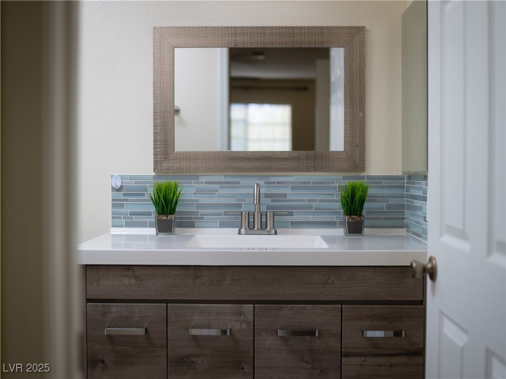 3318 North Decatur Boulevard, Unit 2149 Las Vegas, NV 89130 - Photo 7 of 26 Half bath featuring vanity and backsplash