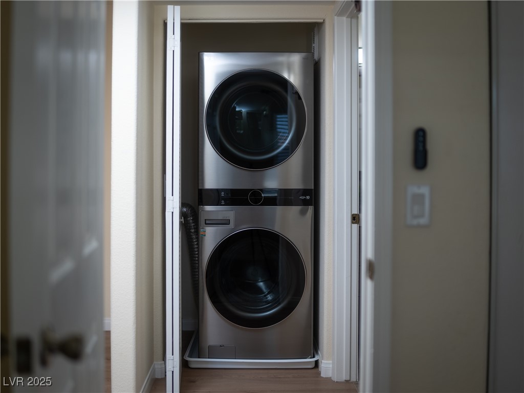 3318 North Decatur Boulevard, Unit 2149 Las Vegas, NV 89130 - Photo 8 of 26 Washroom featuring estacked washer and dryer and wood finished floors