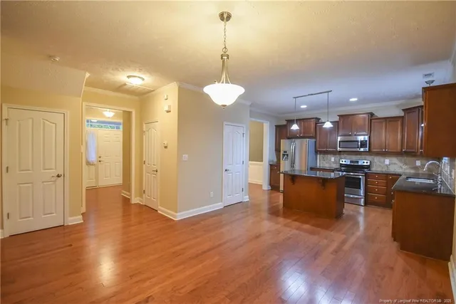 a view of kitchen with stainless steel appliances granite countertop cabinets and wooden floor