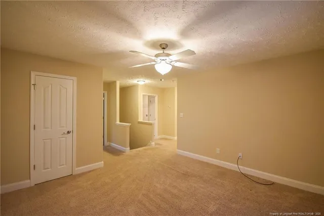 an empty room with a ceiling fan and a window