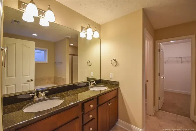 a bathroom with a granite countertop sink and a mirror