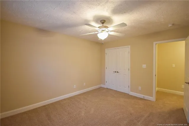 an empty room with a ceiling fan and a window