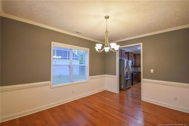 a view of a room with wooden floor chandeliers and kitchen