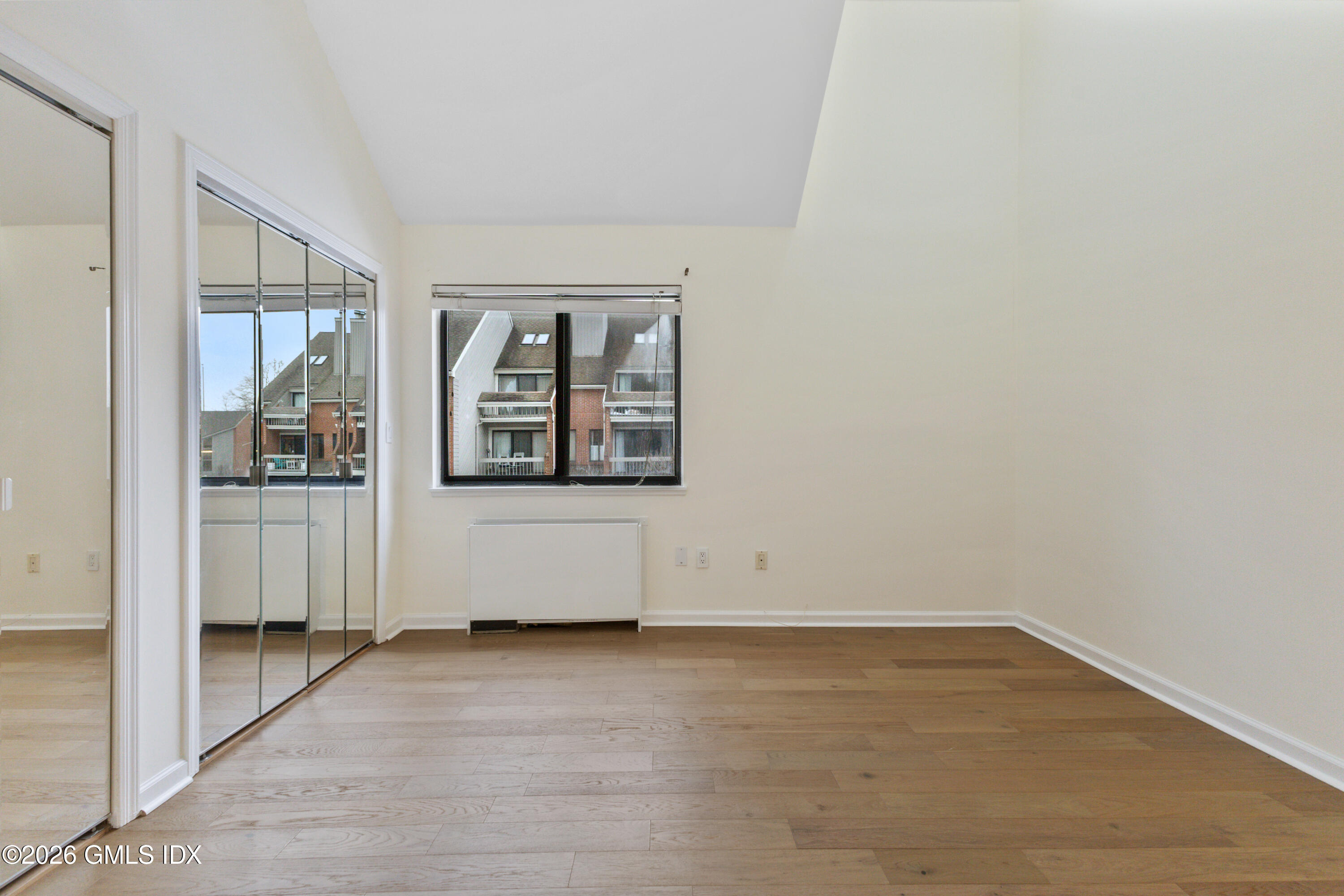 15 River Road, Unit 210 Cos Cob, CT 06807 - Photo 17 of 23 an empty room with wooden floor and windows