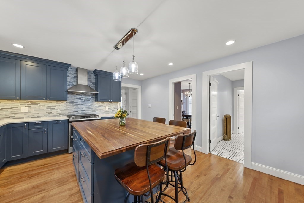 20 Columbus Avenue Beverly, MA 01915 - Photo 16 of 39 a kitchen with stainless steel appliances kitchen island granite countertop a table chairs sink and cabinets