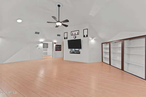 a view of an empty room with a kitchen and a window