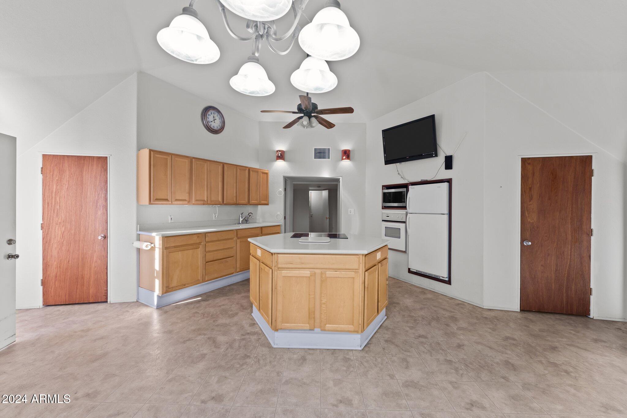 30857 Wandering Way Congress, AZ 85332 - Photo 17 of 35 a living room with kitchen island granite countertop furniture and a fireplace