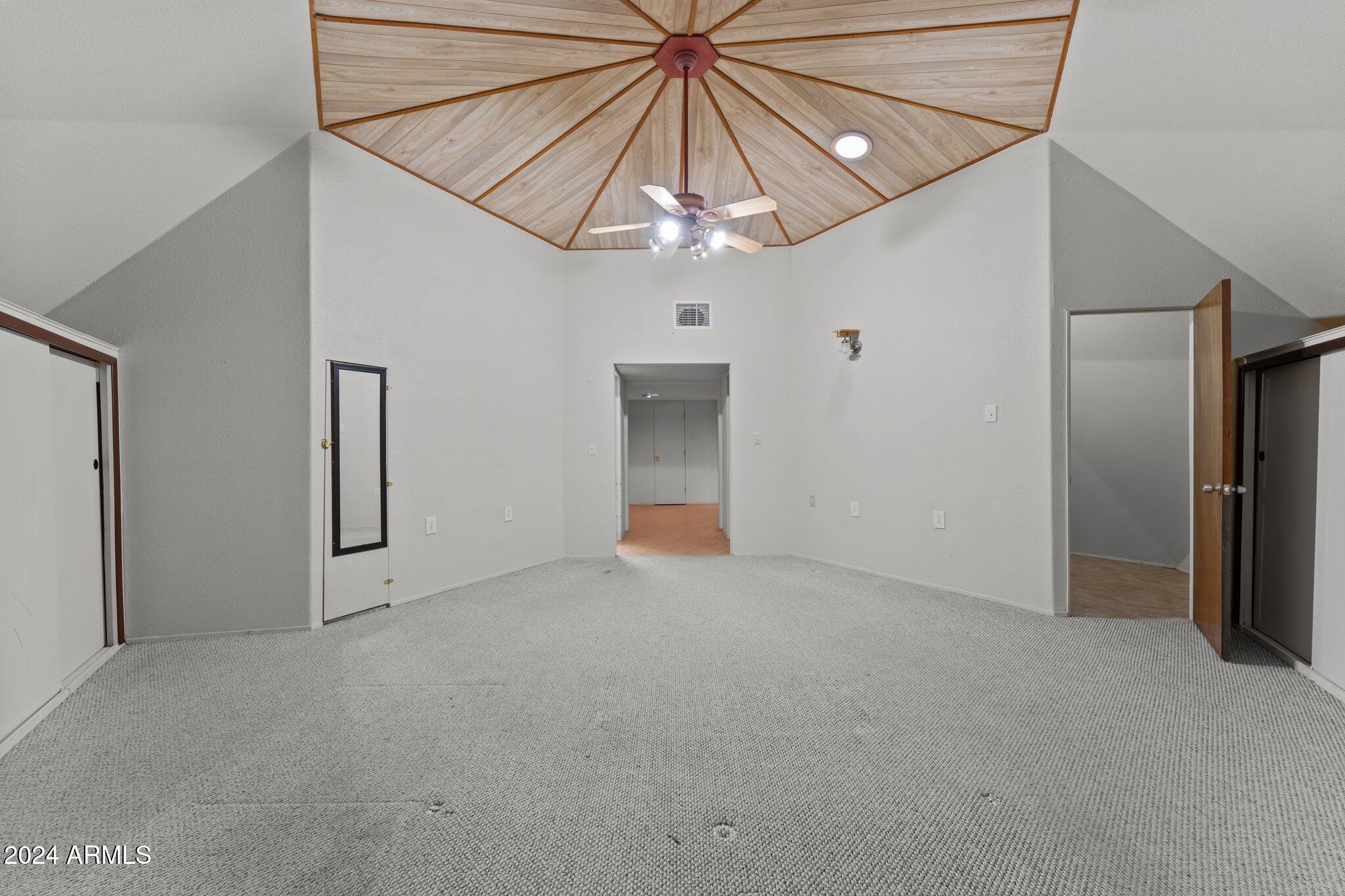 30857 Wandering Way Congress, AZ 85332 - Photo 22 of 35 an empty room with chandelier fan and windows