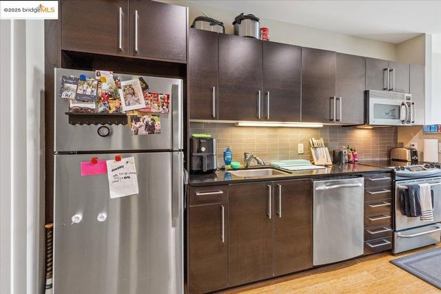 a kitchen with stainless steel appliances granite countertop a refrigerator and a stove