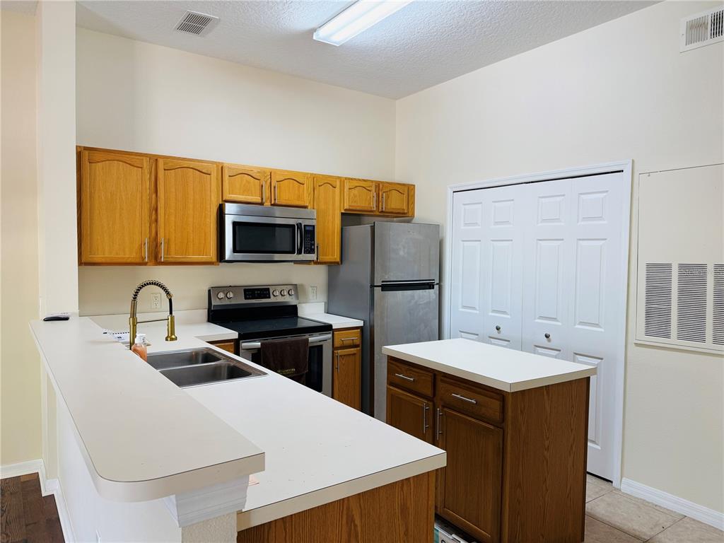 970 North Spring Garden Avenue, Unit 311 DeLand, FL 32720 - Photo 6 of 16 a kitchen with a sink a stove and refrigerator