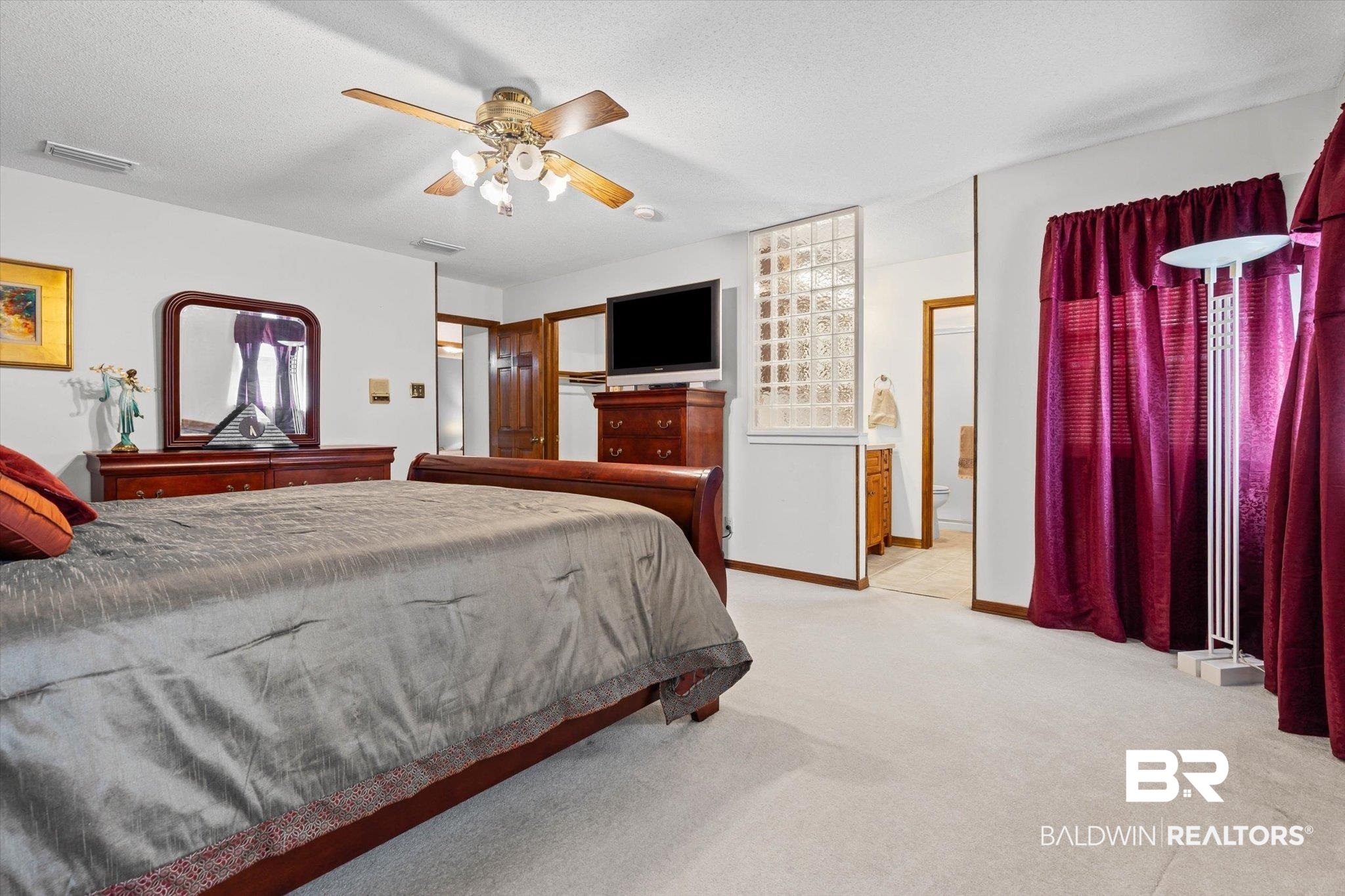 1900 Foxfire Road Mobile, AL 36618 - Photo 14 of 36 Bedroom with light colored carpet, ceiling fan, a textured ceiling, and ensuite bathroom