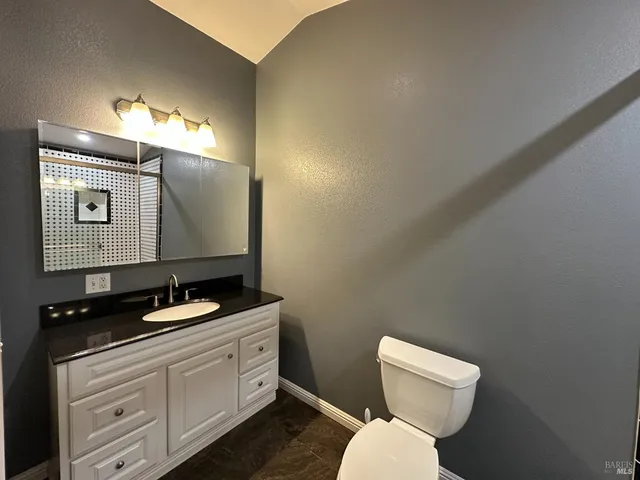 a bathroom with a toilet sink and mirror