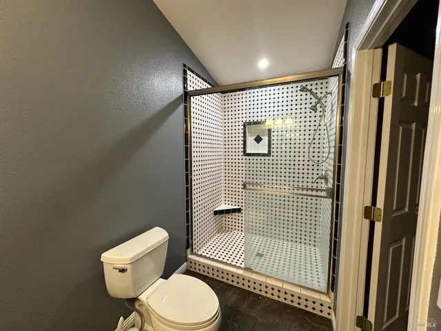 a bathroom with a toilet and a shower
